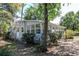 View of the side of house featuring a bright sunroom with ample windows and shaded by mature trees at 17108 Pine Ridge Dr, Umatilla, FL 32784