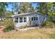 Well-kept single story home featuring green lawn, white picket trim, and mature landscaping at 17108 Pine Ridge Dr, Umatilla, FL 32784
