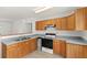 Bright kitchen with wood cabinets, laminate countertops, white backsplash, and wood-look floors at 17108 Pine Ridge Dr, Umatilla, FL 32784