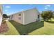 Exterior view of the home showcasing the manicured backyard and covered patio at 1773 Hallandale Ln, The Villages, FL 32162