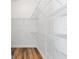 Walk-in closet has wood-look flooring and wire shelving for organizing clothes and accessories at 1773 Hallandale Ln, The Villages, FL 32162