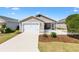 Charming single-story home featuring a white picket fence, well-manicured lawn, and attached two-car garage at 1773 Hallandale Ln, The Villages, FL 32162