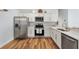 Modern kitchen featuring stainless steel appliances, white cabinets, and wood-look flooring, perfect for culinary enthusiasts at 1773 Hallandale Ln, The Villages, FL 32162