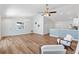 Open living space with wood floors, stylish lighting, and seamless flow to the kitchen at 1773 Hallandale Ln, The Villages, FL 32162