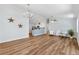 Bright, open-concept living room with wood floors that flows into the modern kitchen and dining area at 1773 Hallandale Ln, The Villages, FL 32162