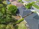 An aerial view of a home with mature trees, a well-manicured lawn, and a dark gray roof at 17883 Se 125Th Cir, Summerfield, FL 34491