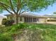 Lush backyard featuring a well-manicured lawn and covered patio creating an outdoor retreat at 17883 Se 125Th Cir, Summerfield, FL 34491