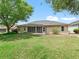 Expansive backyard with manicured lawn and home exterior, perfect for relaxing or entertaining at 17883 Se 125Th Cir, Summerfield, FL 34491