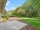 Manicured backyard with lush grass, privacy hedge, and a concrete patio for outdoor enjoyment at 17883 Se 125Th Cir, Summerfield, FL 34491