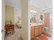 Open view into an ensuite bathroom, complete with tile flooring and warm-toned cabinets at 17883 Se 125Th Cir, Summerfield, FL 34491