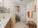 Bathroom with walk-in shower featuring neutral tile, a double vanity, and tile floors at 17883 Se 125Th Cir, Summerfield, FL 34491