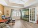 Bright bedroom features a tray ceiling, white plantation shutters, and a decorative painted wardrobe at 17883 Se 125Th Cir, Summerfield, FL 34491