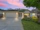 Charming single-story home featuring manicured landscaping, a two-car garage, and a well-lit entryway at 17883 Se 125Th Cir, Summerfield, FL 34491