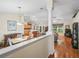 An open-concept living space with hardwood floors, a decorative column, and views of the kitchen at 17883 Se 125Th Cir, Summerfield, FL 34491