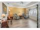 Cozy living room featuring comfortable seating, a tray ceiling, wood look floors, and lots of natural light at 17883 Se 125Th Cir, Summerfield, FL 34491