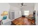 Cozy bedroom featuring hardwood floors, ceiling fan, and ample natural light at 1907 Anderson Ct, The Villages, FL 32162