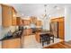 Well-lit kitchen featuring wood cabinets, stainless steel appliances, granite counters, and a central island at 1907 Anderson Ct, The Villages, FL 32162