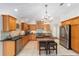 Bright and modern kitchen equipped with stainless steel appliances, wood cabinets, and a functional center island at 1907 Anderson Ct, The Villages, FL 32162