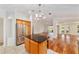 Open-concept kitchen featuring stainless steel appliances and an island with seating flowing into the dining area at 1907 Anderson Ct, The Villages, FL 32162