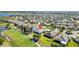 Beautiful aerial view of a home next to a golf course and a scenic lake in a suburban neighborhood at 2213 Evans Prairie Trl, The Villages, FL 32163