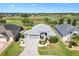 Stunning aerial view of a home on a golf course with meticulously landscaped grounds and a beautiful paver driveway at 2213 Evans Prairie Trl, The Villages, FL 32163