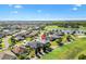 Expansive aerial view of a home on a golf course community with a lake and manicured lawns at 2213 Evans Prairie Trl, The Villages, FL 32163