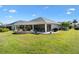 Spacious backyard featuring a patio, outdoor grill, and a screened lanai at 2213 Evans Prairie Trl, The Villages, FL 32163