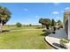 Manicured lawn with paved patio and fire pit overlooking the golf course at 2213 Evans Prairie Trl, The Villages, FL 32163