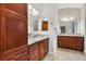 Double vanity bathroom with wood cabinets, granite countertops, and ample lighting at 2213 Evans Prairie Trl, The Villages, FL 32163