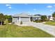 Beautiful home with a lush front lawn, paver driveway, and a two-car garage, set in a serene neighborhood at 2213 Evans Prairie Trl, The Villages, FL 32163