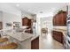 Bright kitchen featuring granite countertops, stainless steel appliances, and dark wood cabinets, open to the dining area at 2213 Evans Prairie Trl, The Villages, FL 32163