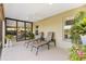 Inviting lanai featuring ceiling fan, neutral decor, and view into the living area at 2213 Evans Prairie Trl, The Villages, FL 32163