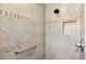 Tiled shower featuring a shower niche, shower head, grab bar and decorative accent tile at 2213 Evans Prairie Trl, The Villages, FL 32163