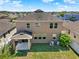 Aerial view of a two-story home with a grassy fenced backyard, covered patio, and air conditioning units at 2520 Tanner Ter, Kissimmee, FL 34743