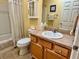 Well-lit bathroom featuring a single sink vanity, toilet, and bathtub with shower curtain at 2569 Errol Ter, The Villages, FL 32162