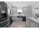 Contemporary kitchen featuring stainless steel appliances, gray cabinets, and a stylish farmhouse sink at 2716 Benavides Dr, The Villages, FL 32162