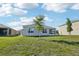The backyard features a lush green lawn and the home's screened-in patio at 2916 Canary Ln, Tavares, FL 32778