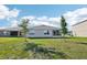 Home's backyard with newly planted trees and manicured lawn, offering relaxation and recreation at 2916 Canary Ln, Tavares, FL 32778