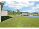 The backyard features a scenic pond view, a lush green lawn, and new landscaping at 2916 Canary Ln, Tavares, FL 32778