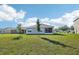 Expansive backyard featuring a spacious lawn and an enclosed screened-in patio at 2916 Canary Ln, Tavares, FL 32778