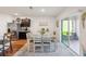 Dining area boasts modern table and chairs next to kitchen with stainless steel refrigerator at 2916 Canary Ln, Tavares, FL 32778