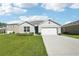 Charming single-story home featuring a well-manicured lawn and a two-car garage on a sunny day at 2916 Canary Ln, Tavares, FL 32778