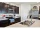 Kitchen close-up showcasing stainless steel appliances, dark cabinetry, and laminate countertops at 2916 Canary Ln, Tavares, FL 32778