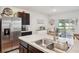 Kitchen with stainless steel refrigerator, dark cabinets, and island overlooking dining area at 2916 Canary Ln, Tavares, FL 32778