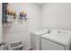 Functional laundry area with white appliances and storage shelves, offering convenience and organization at 2916 Canary Ln, Tavares, FL 32778