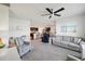 Open-concept living room with ceiling fan, plush carpet, and comfortable seating area at 2916 Canary Ln, Tavares, FL 32778