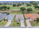 Aerial view of the home with a golf course and water views in the distance with neighboring houses at 30454 Island Club Dr, Deer Island, FL 32778