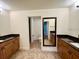 Bathroom featuring double sink vanity with granite counters and a door to a toilet room at 30454 Island Club Dr, Deer Island, FL 32778