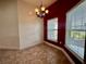 Bright dining area with two windows, an elegant light fixture, and tile flooring at 30454 Island Club Dr, Deer Island, FL 32778