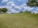 Scenic golf course view with lush green fairways and mature trees under a bright sky, showcasing the community's landscape at 30454 Island Club Dr, Deer Island, FL 32778